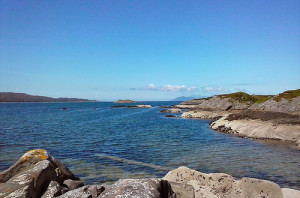 beach water with rocks and blue sky