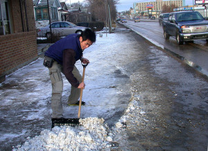 shoveling snow in front of a store