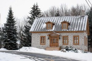 stone home covered in snow