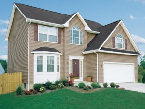 A two-story home with brown siding and white-frame windows.