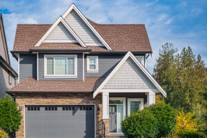 Suburban home with brown roof, gray siding, and white-framed windows