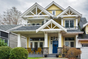 Yellow suburban home with blue front door and white gables