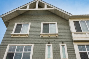 Home with green siding and white-framed windows